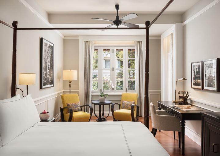 a room with a bed and a desk and chairs