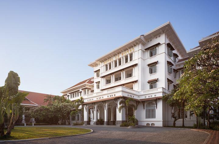 a large white building with trees and a paved road