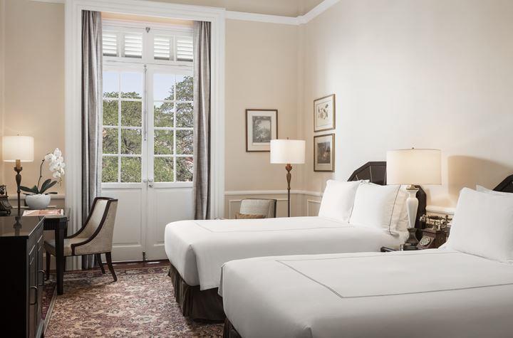 a room with two beds and a chair