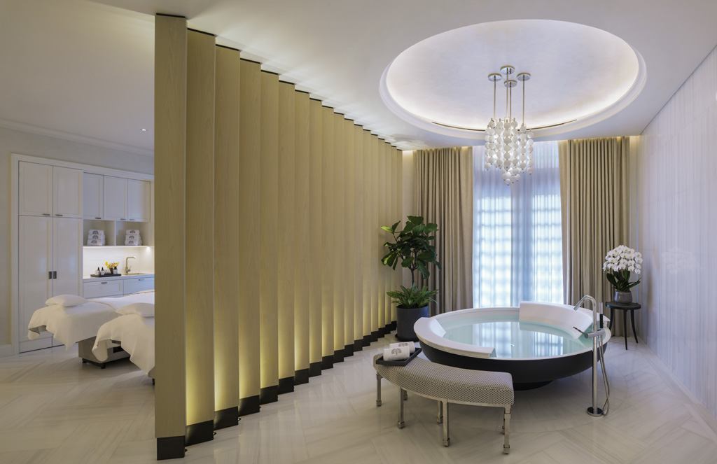 a room with a round tub and a bed
