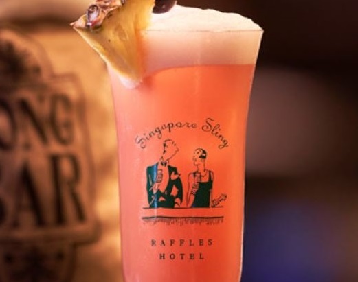 a glass of pink drink with a pineapple slice