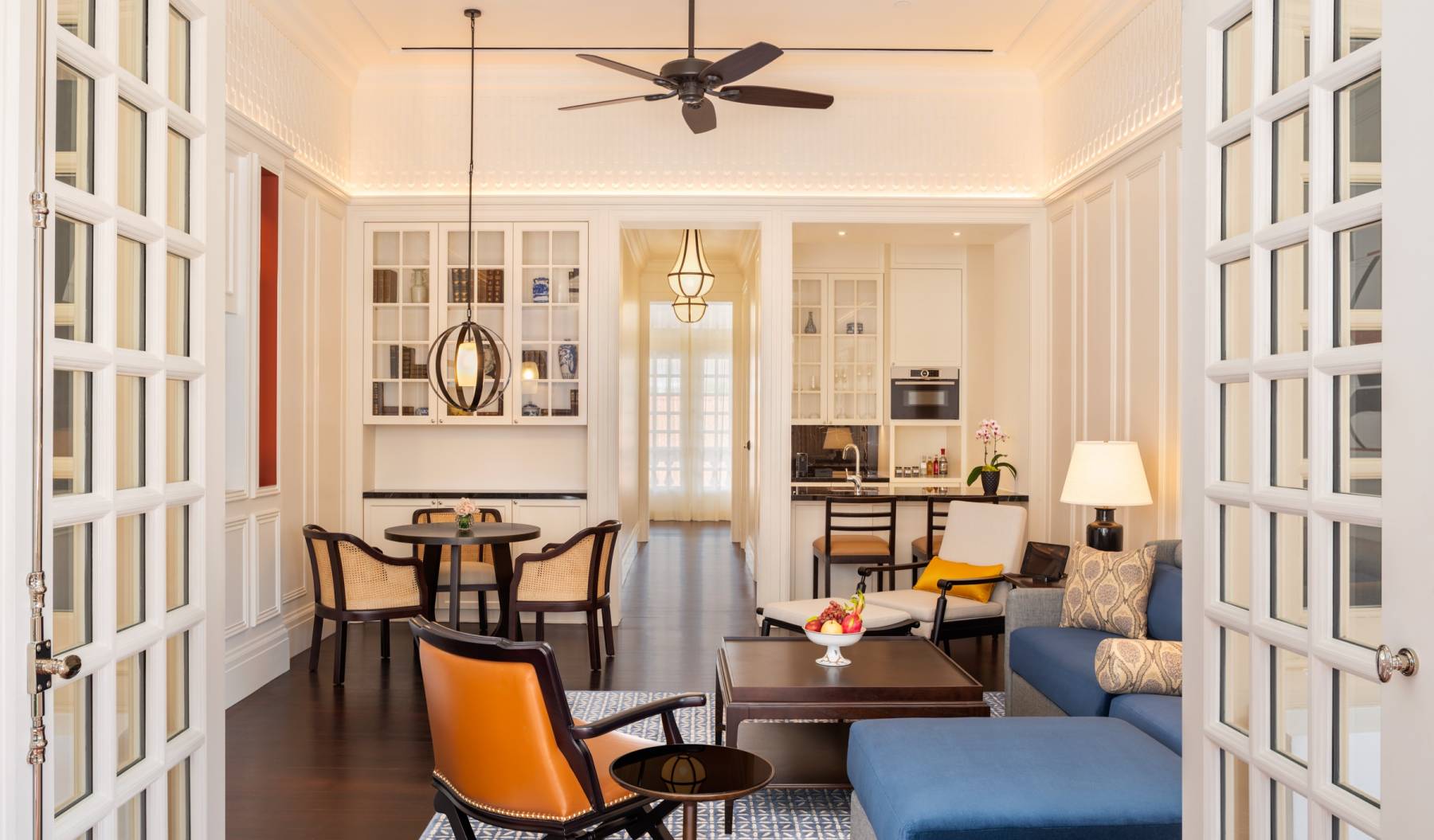 a living room with a ceiling fan and a couch and chairs
