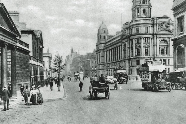 a black and white photo of a street with a horse carriage and people