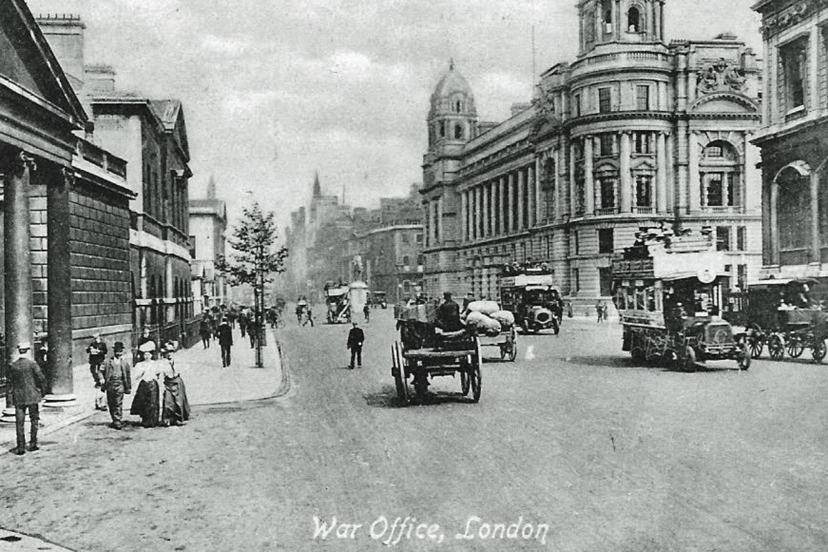 a black and white photo of a street with a horse drawn carriage