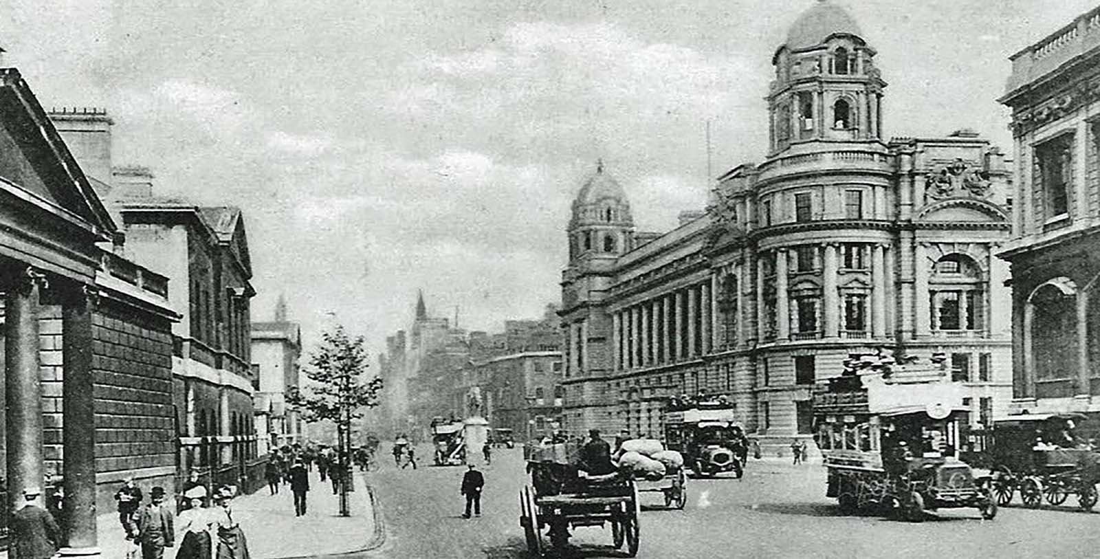 a black and white photo of a street with a large building