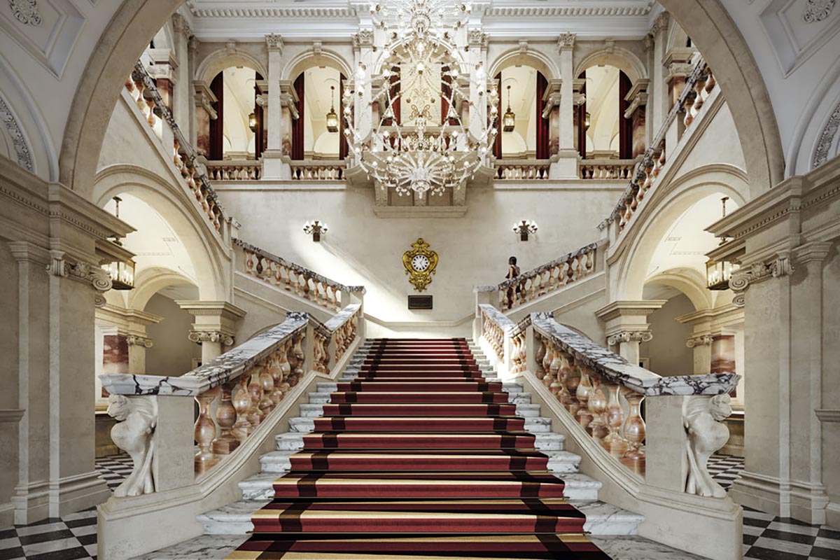 a staircase with red carpet and chandelier