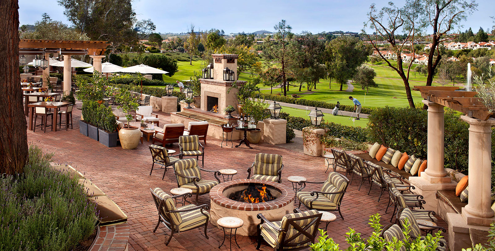a patio with chairs and a fire pit