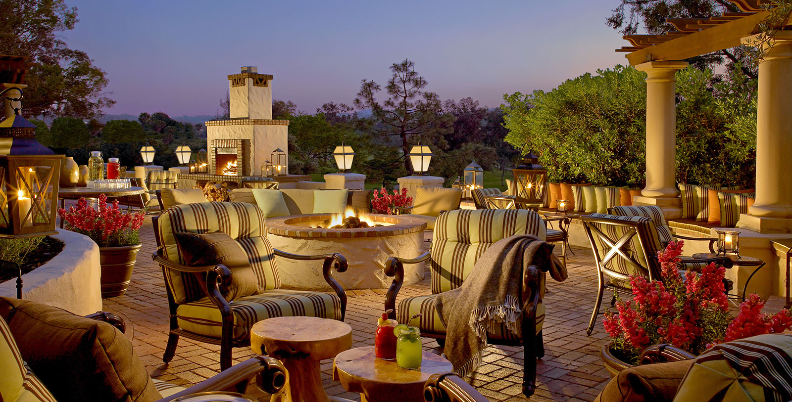 a patio with chairs and a fire pit