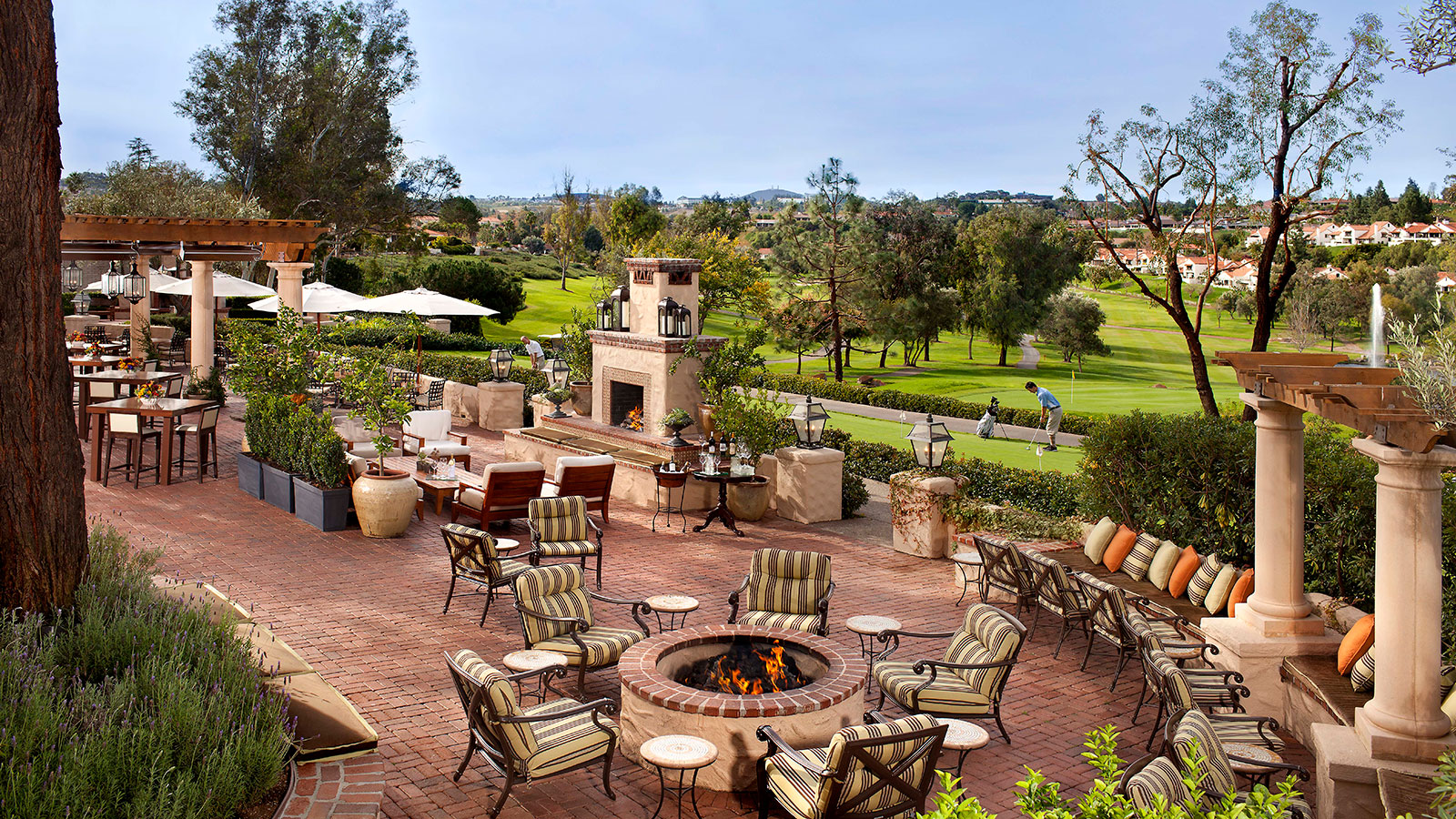 a patio with chairs and a fire pit
