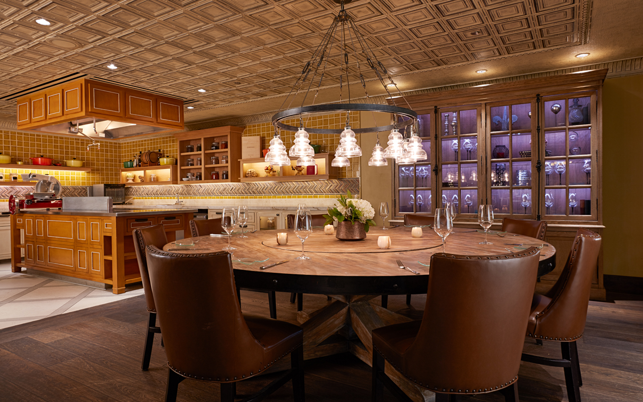 a dining room with a chandelier and wine glasses