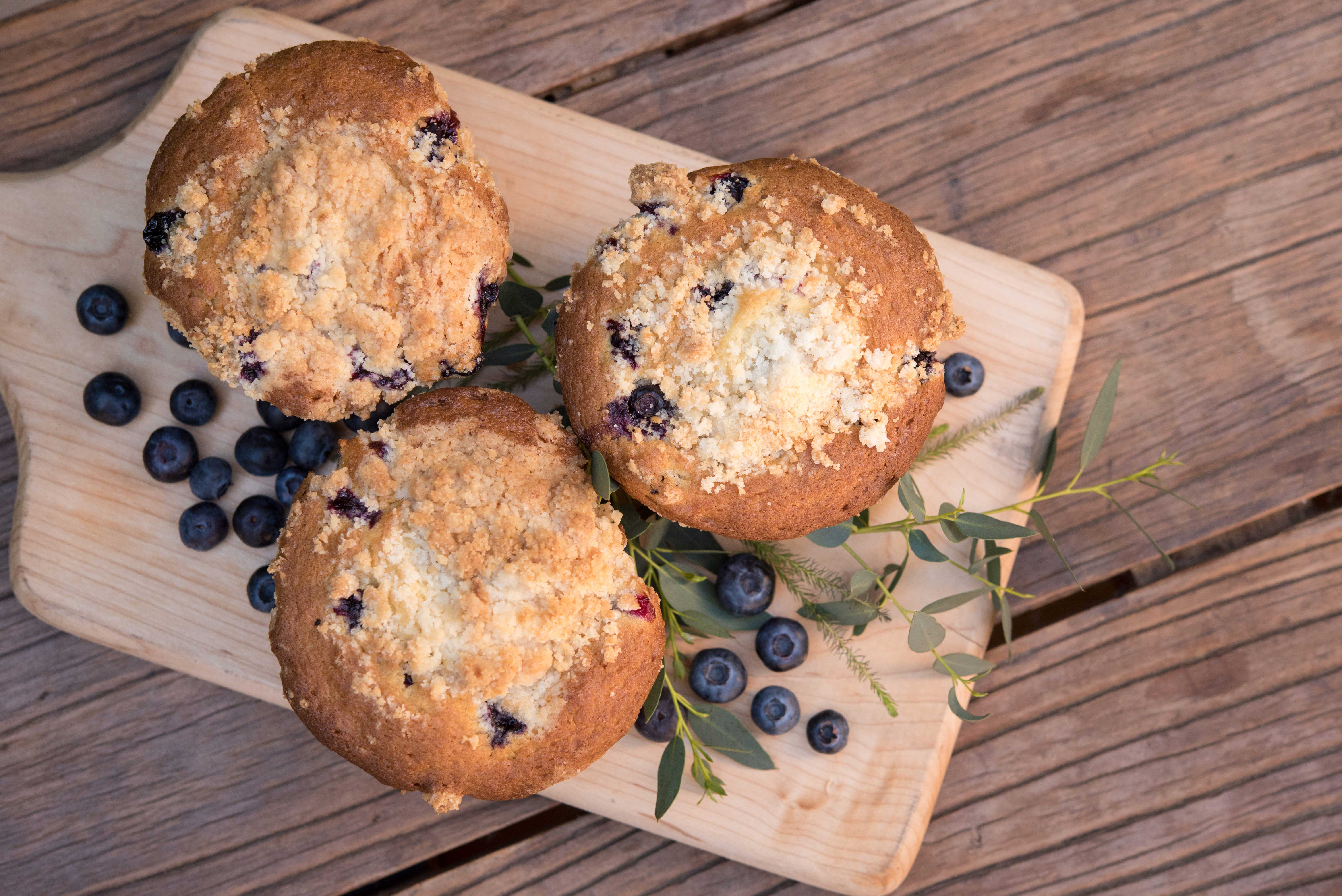 a group of muffins on a wood board
