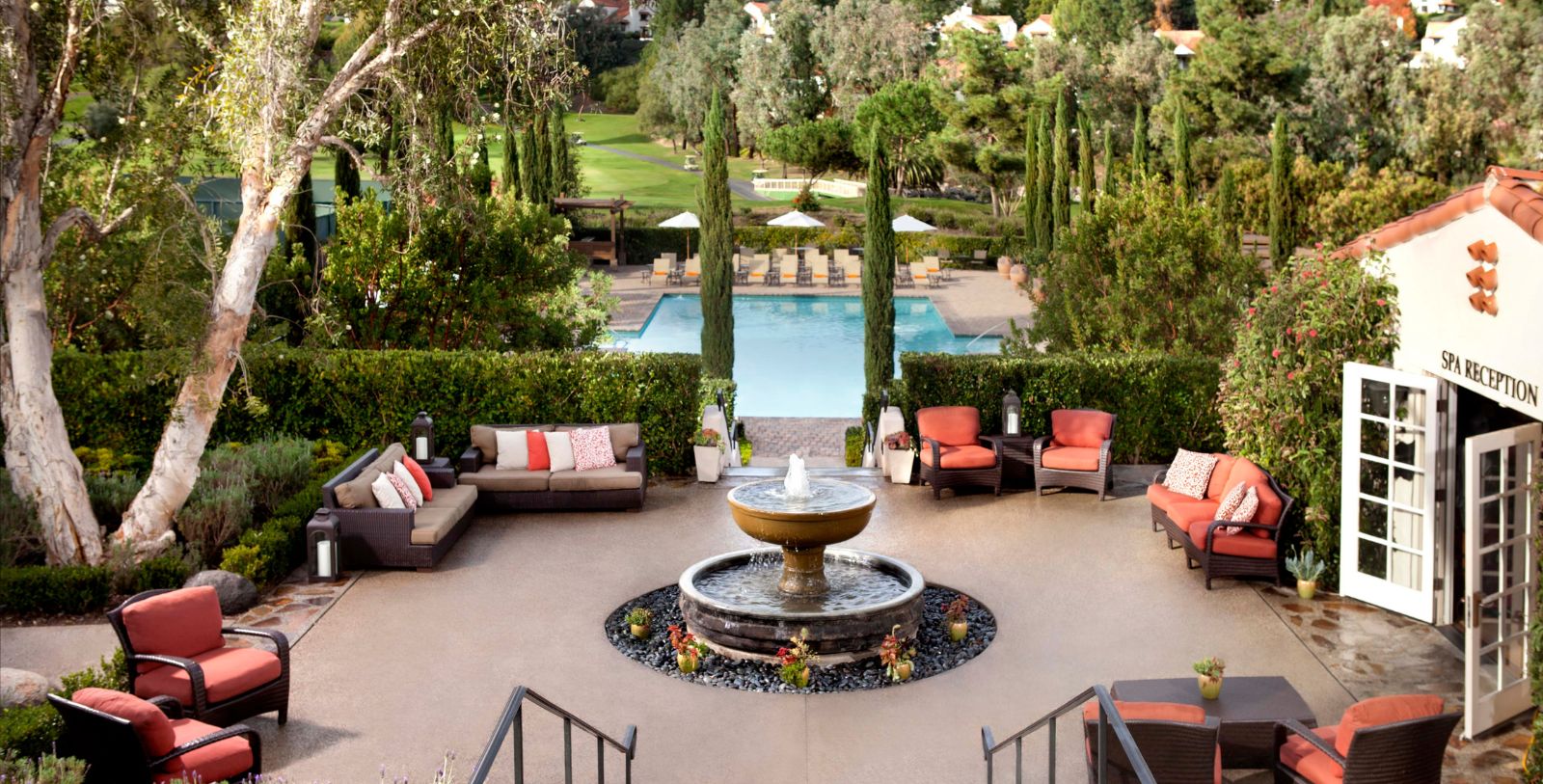 a pool with a fountain and chairs