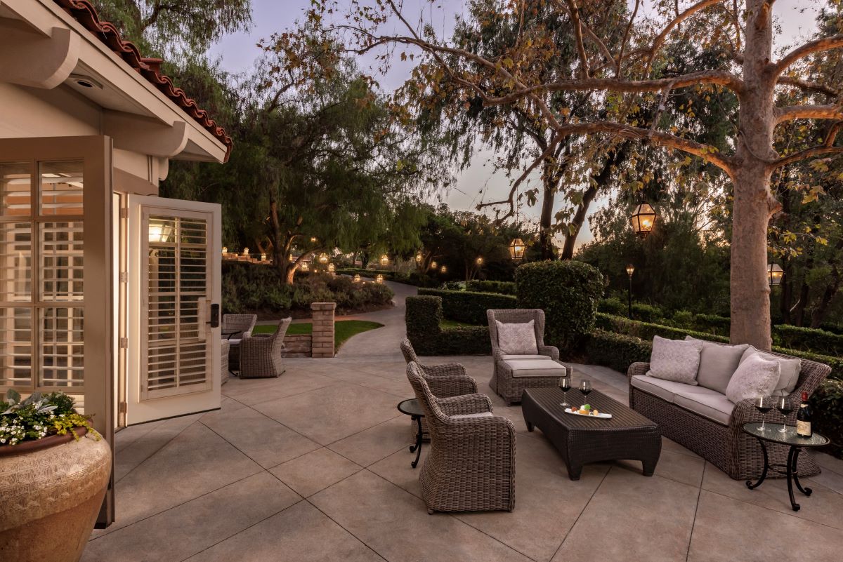 a patio with furniture and a tree