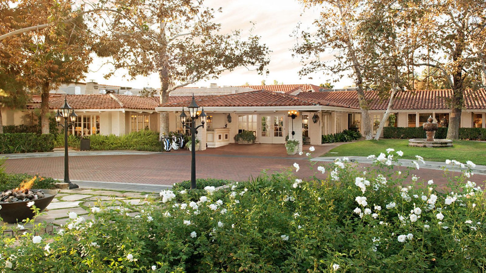 a building with a brick driveway and flowers