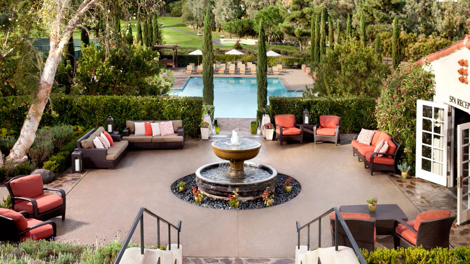 a pool with a fountain and chairs