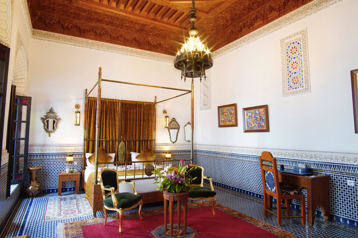a room with a bed and chairs
