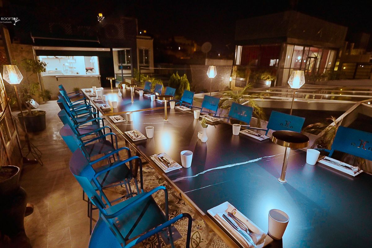 a long table with blue chairs and a lamp on it