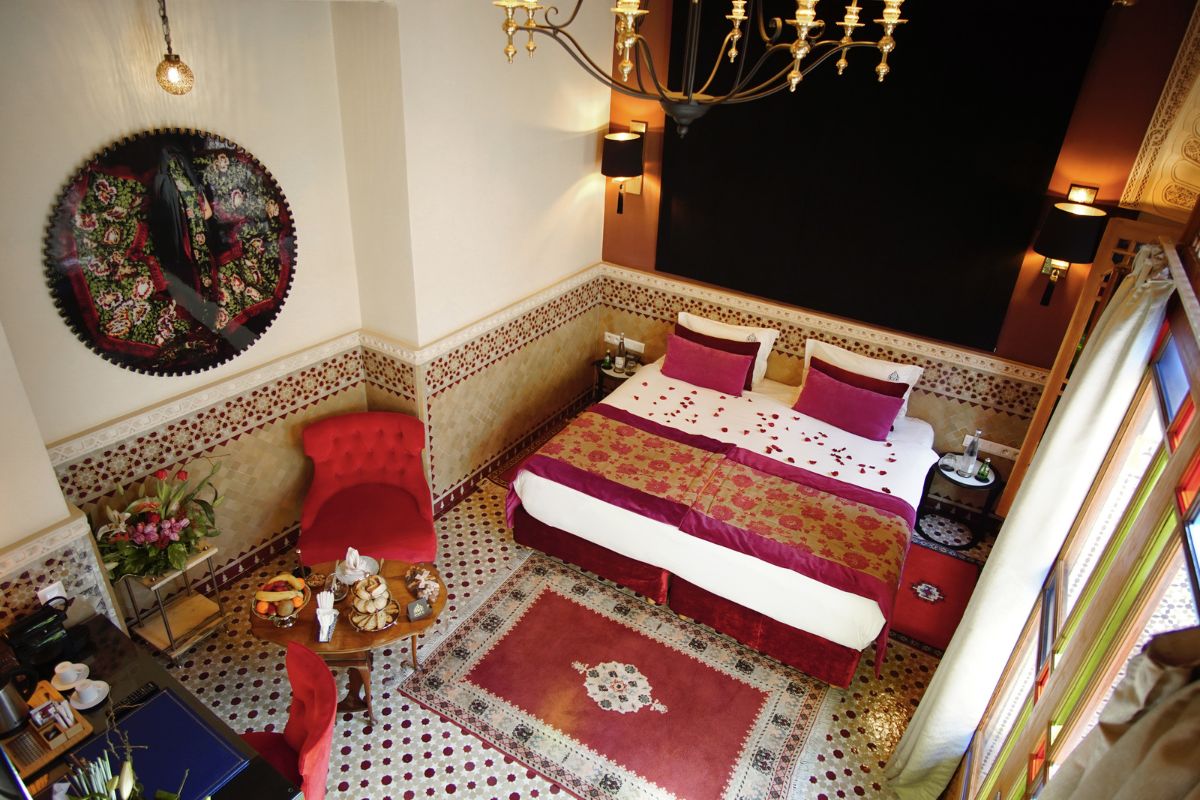 a room with a bed and chairs
