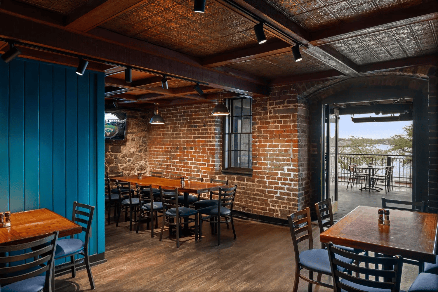 a room with a brick wall and tables and chairs