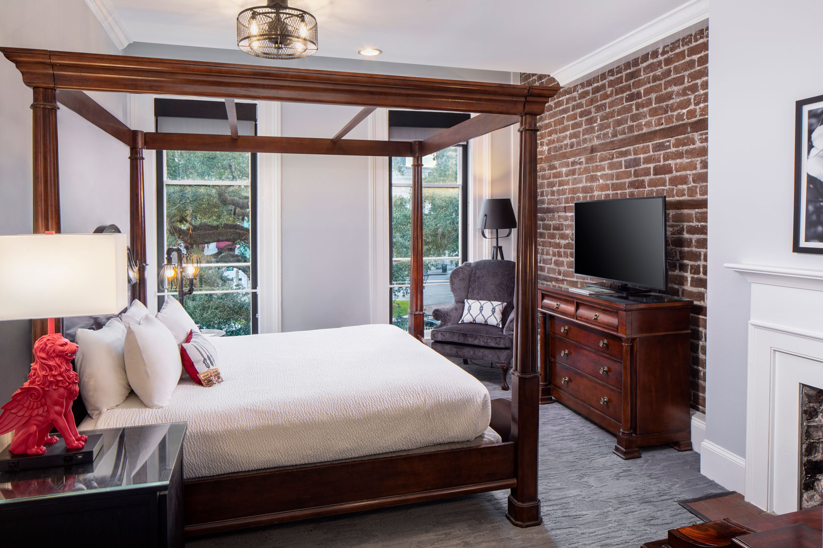 a bedroom with a four poster bed and a brick wall