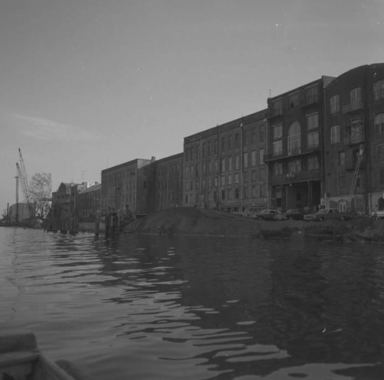 a body of water with buildings and cranes