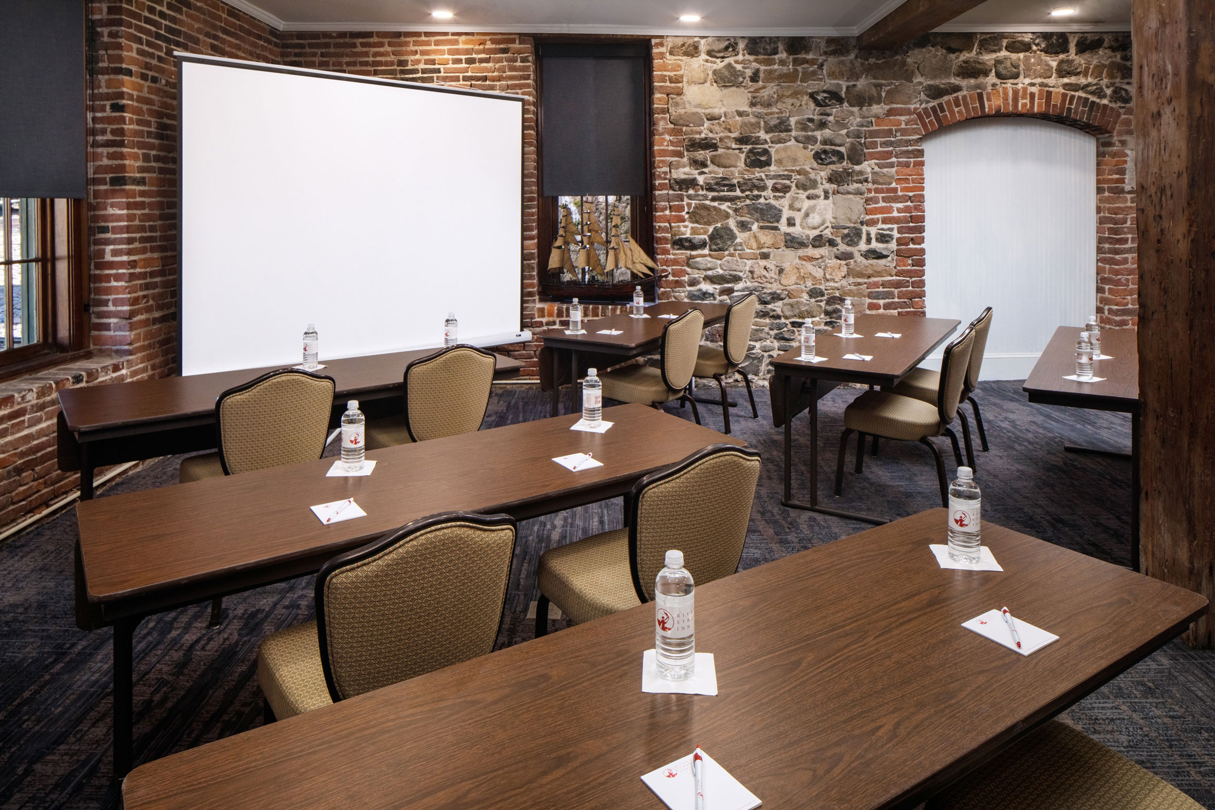 a room with tables and chairs and a white board