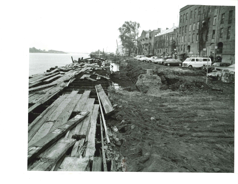 a construction site with a few buildings and a river