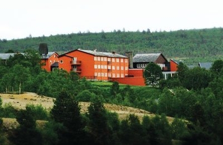 a large red building in the middle of a forest