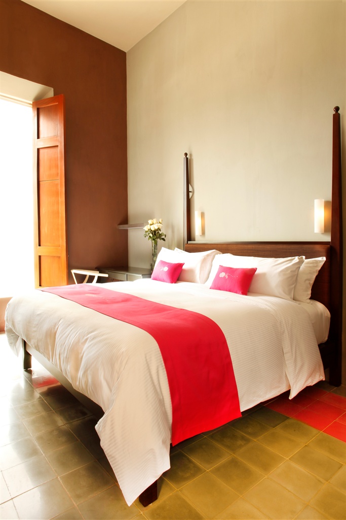 a bed with a red blanket and pillows
