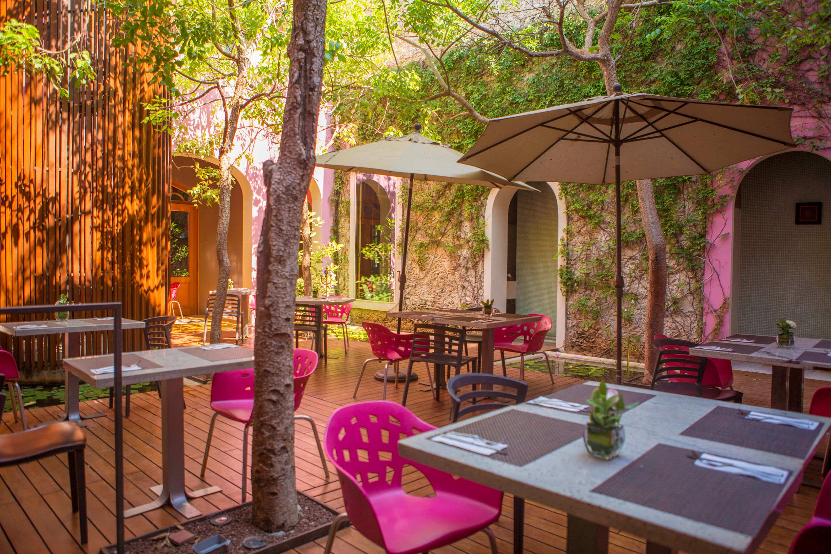 a patio with tables and chairs and umbrellas