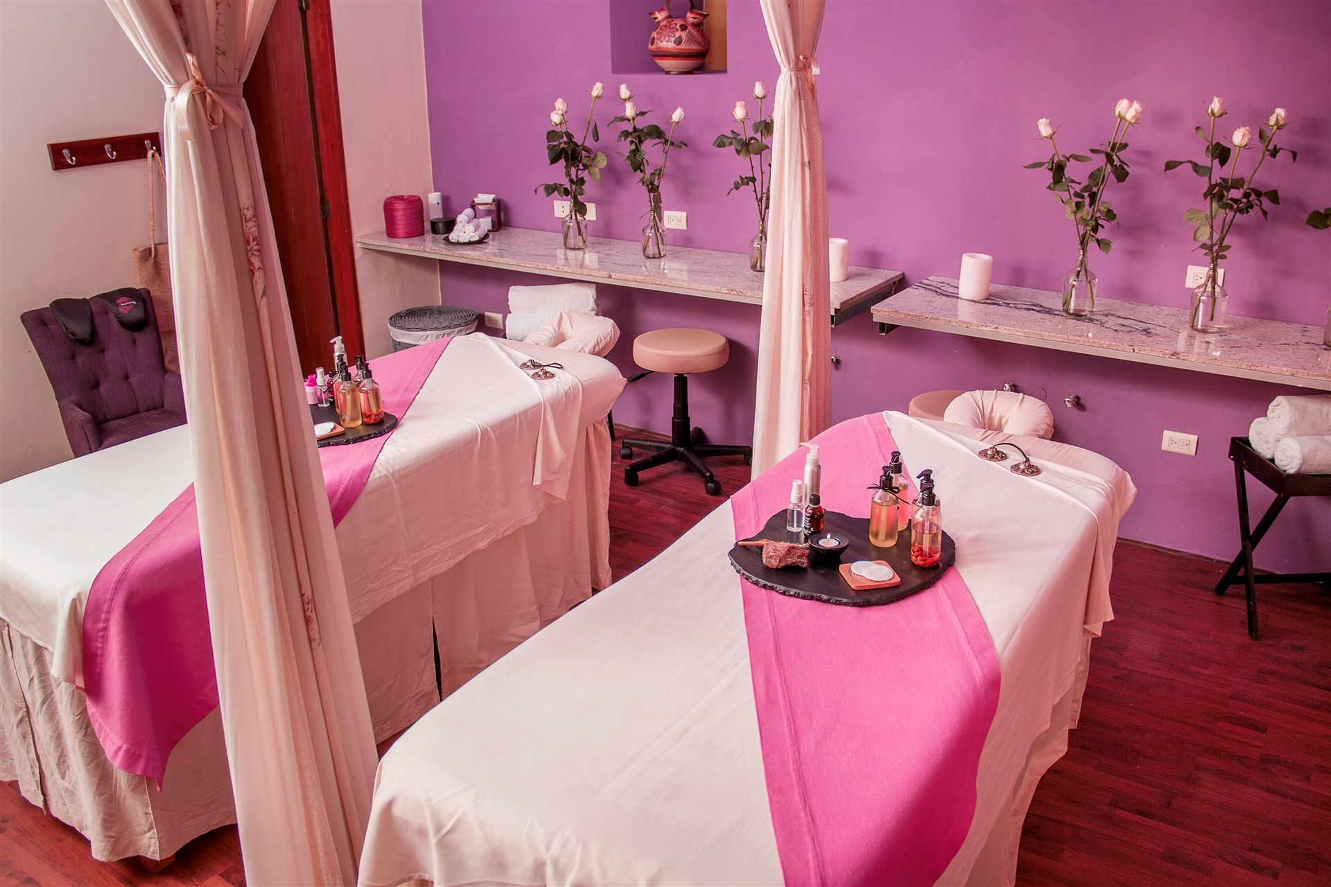 a massage room with pink and white beds