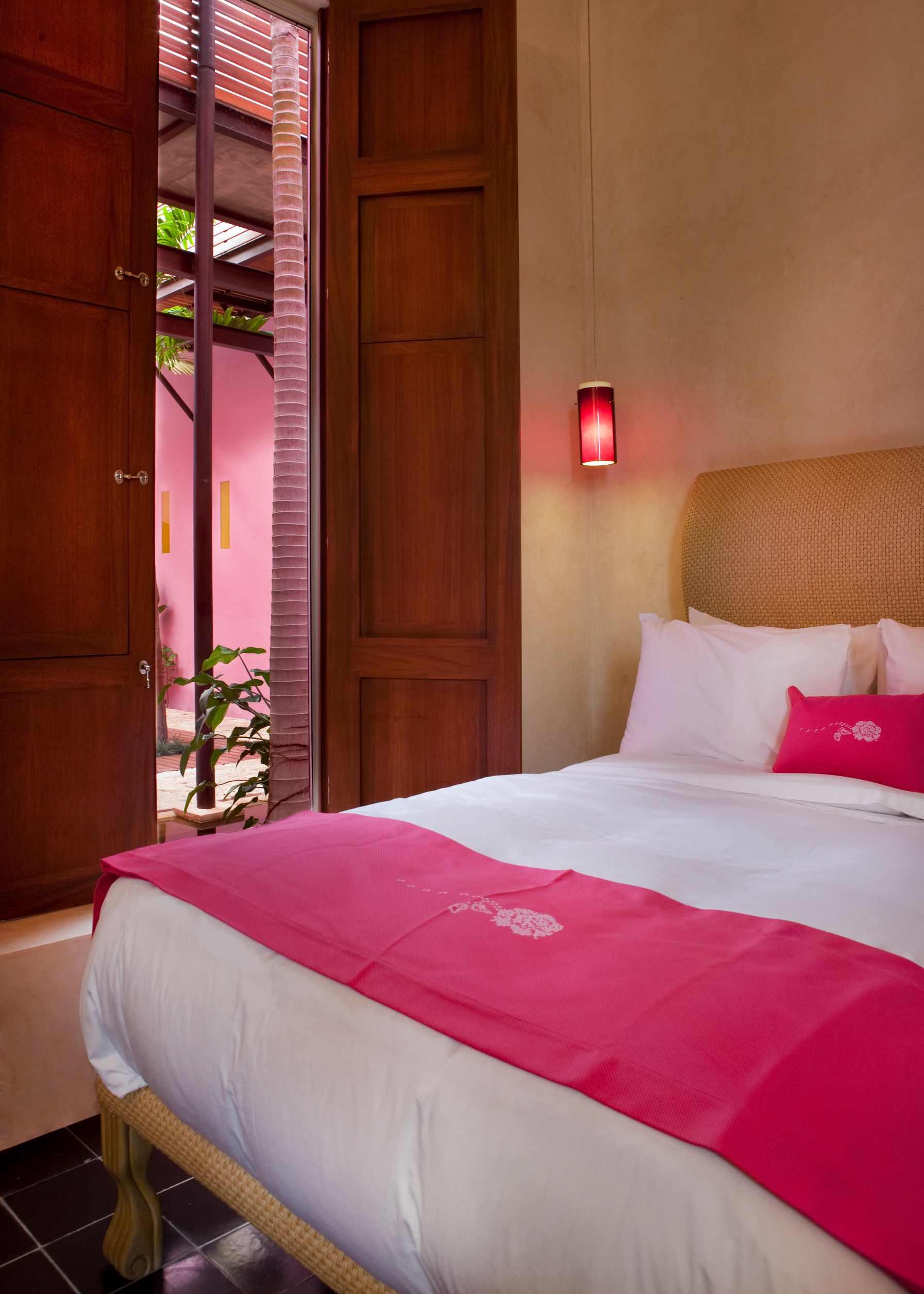 a bed with pink blanket and pillows