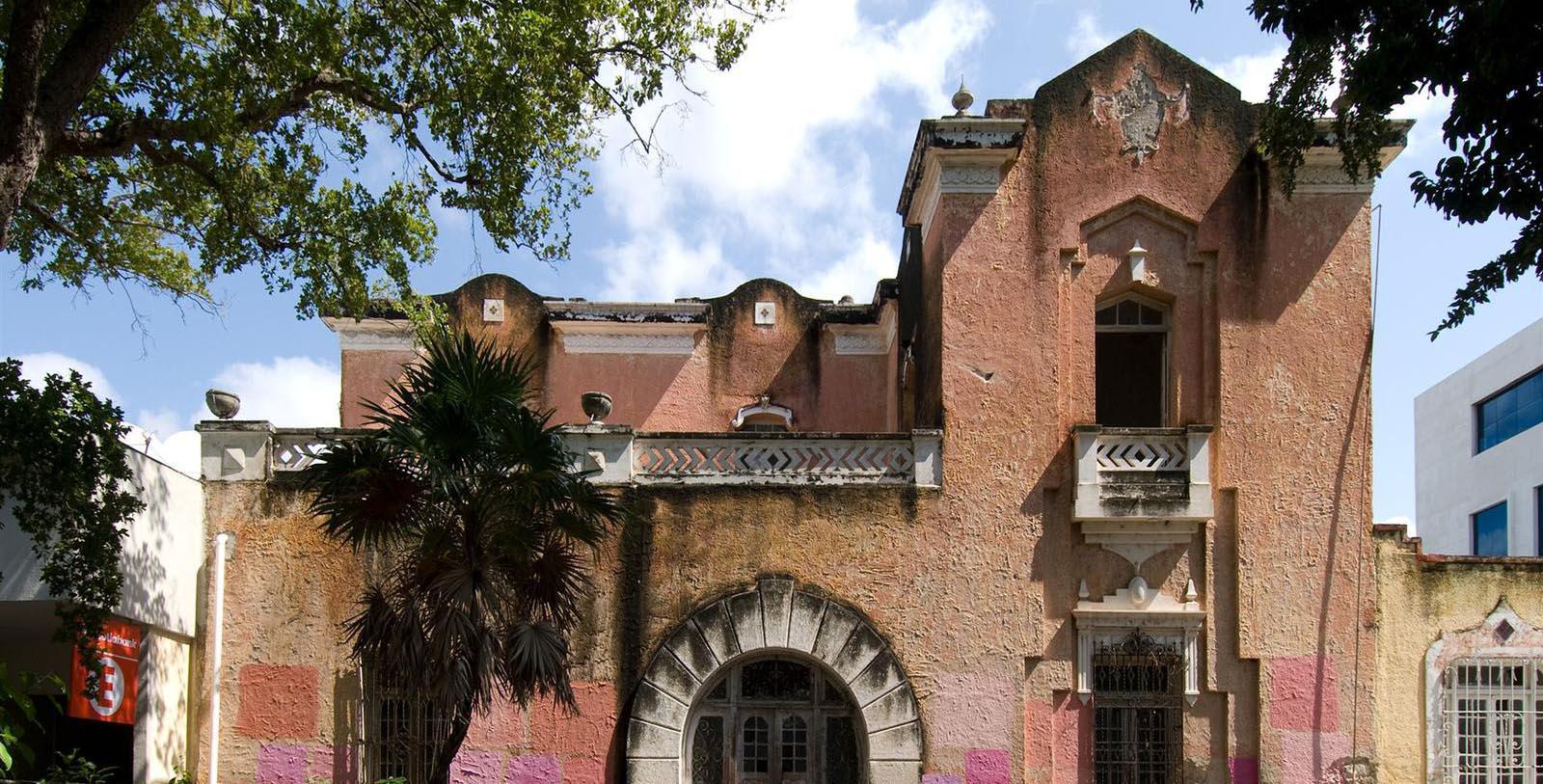 a building with a balcony and a tree