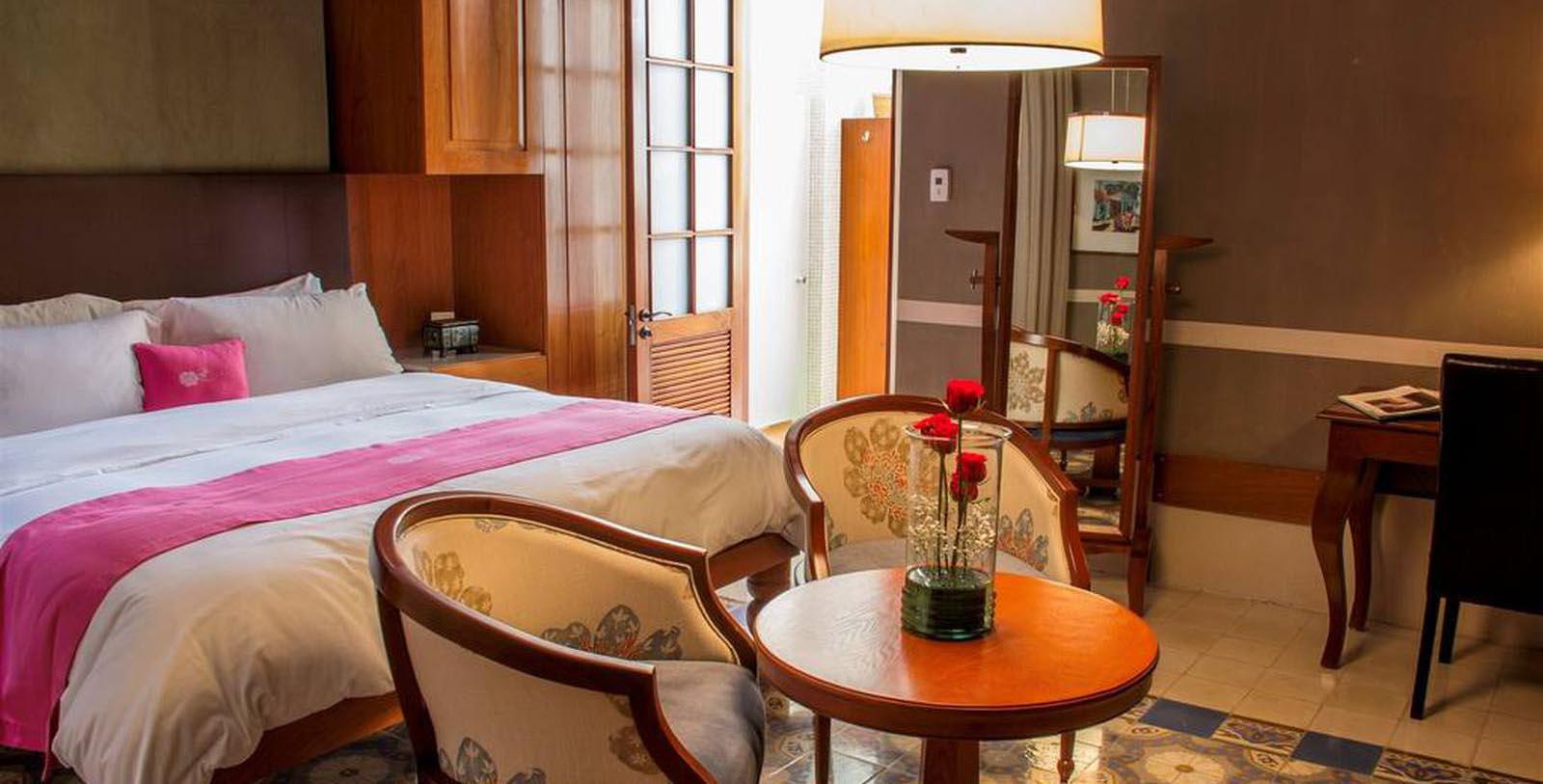 a room with a bed and chairs
