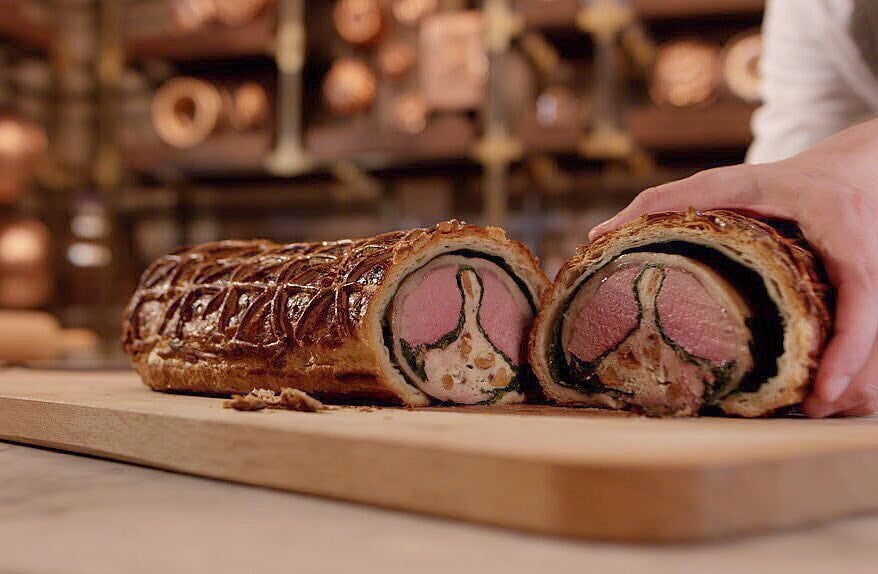 a hand holding a meat roll