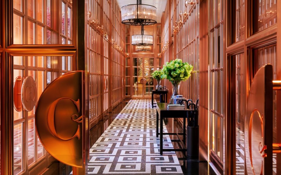 a hallway with glass doors and a table with flowers