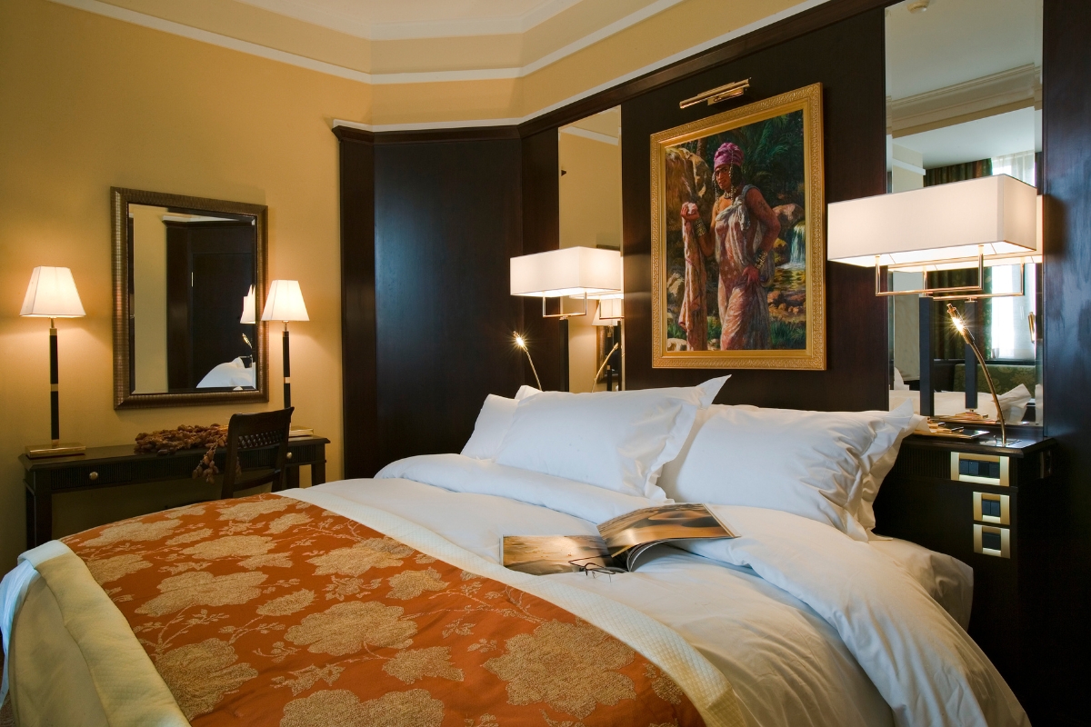 a bed with a painting above it