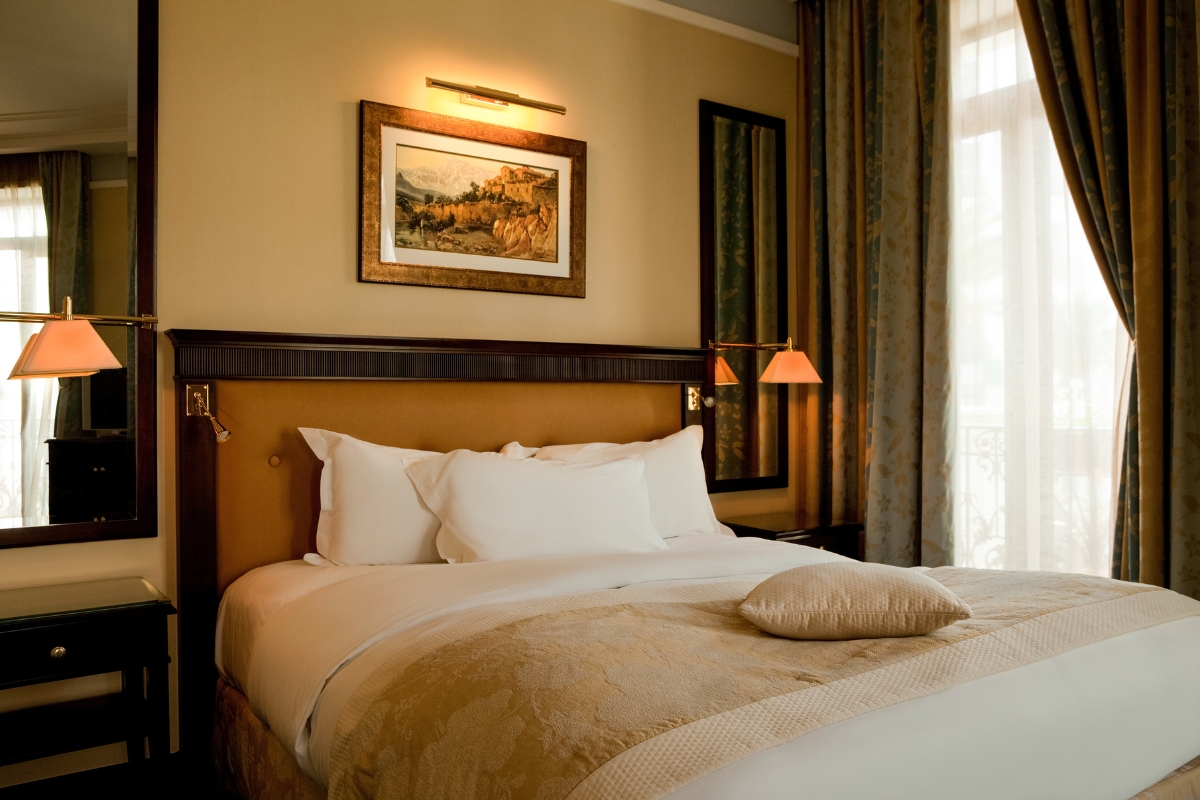 a bed with pillows and a picture on the wall