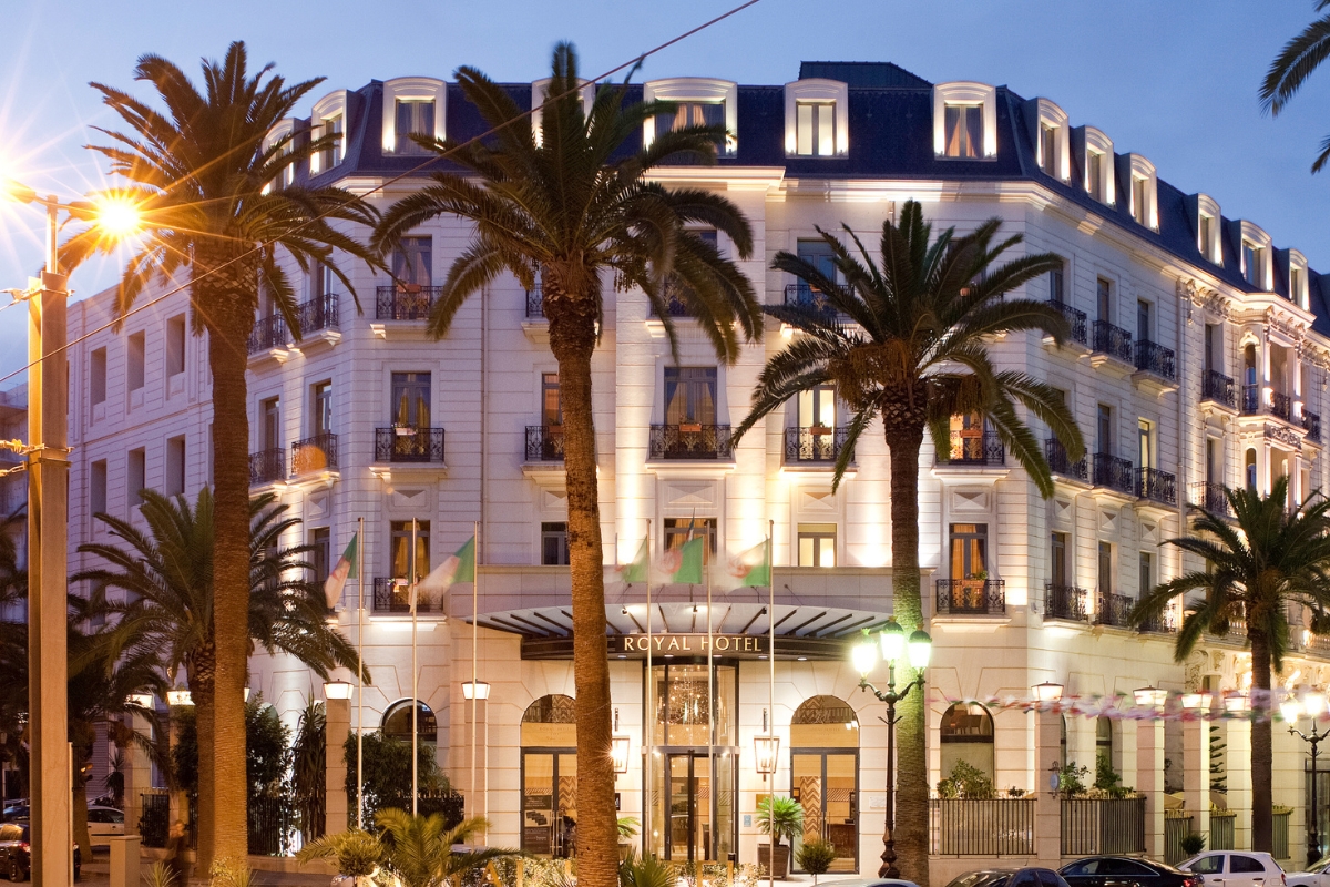 a building with palm trees and lights