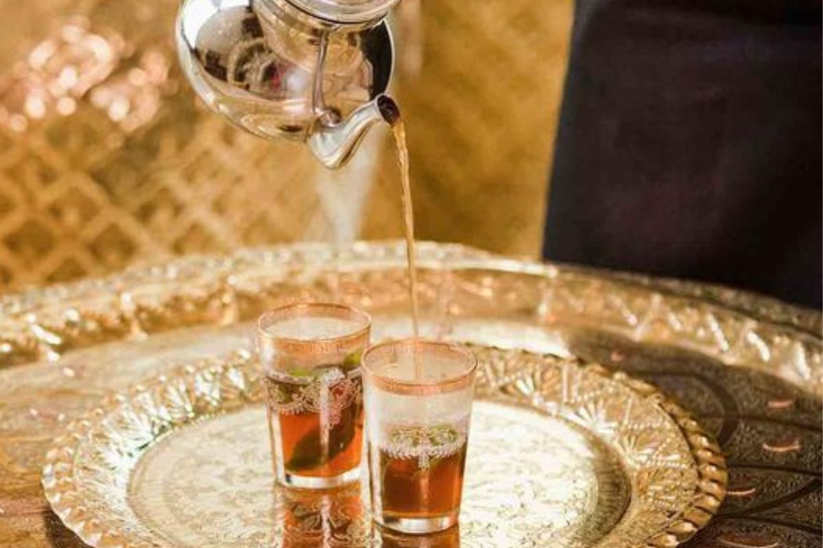 a tea being poured into a glass