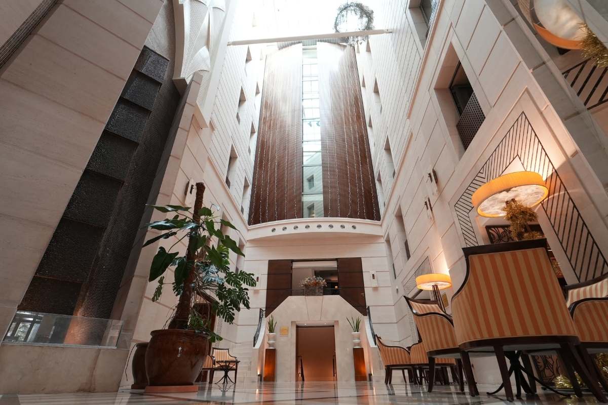 a hallway with a tall ceiling and a tall window