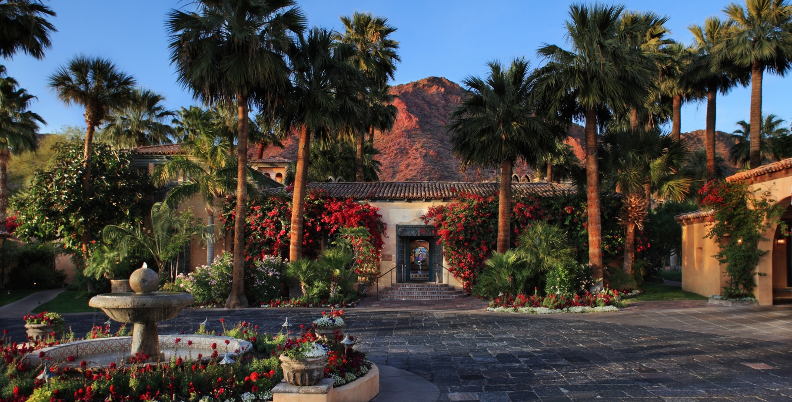 a building with palm trees and flowers