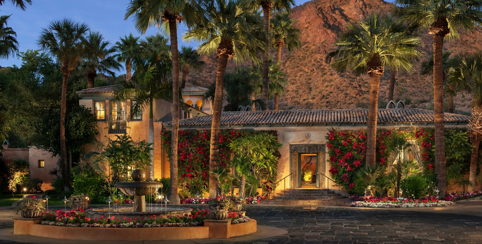 a building with palm trees and a fountain