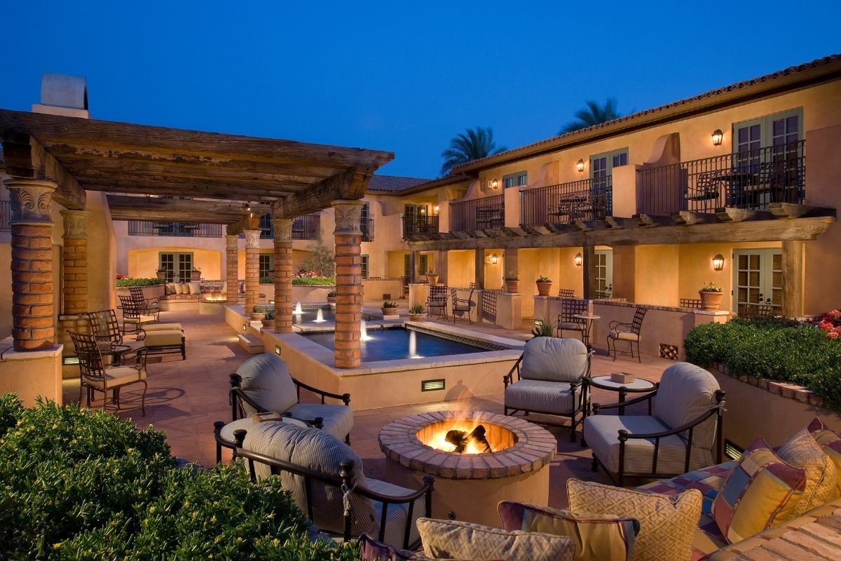 a patio with a fire pit and chairs