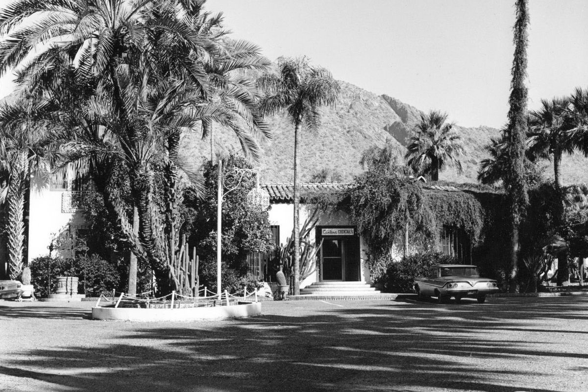 a building with palm trees and a car parked in front of it
