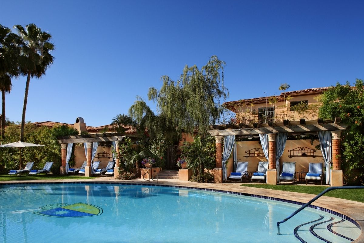 a swimming pool with a gazebo and chairs