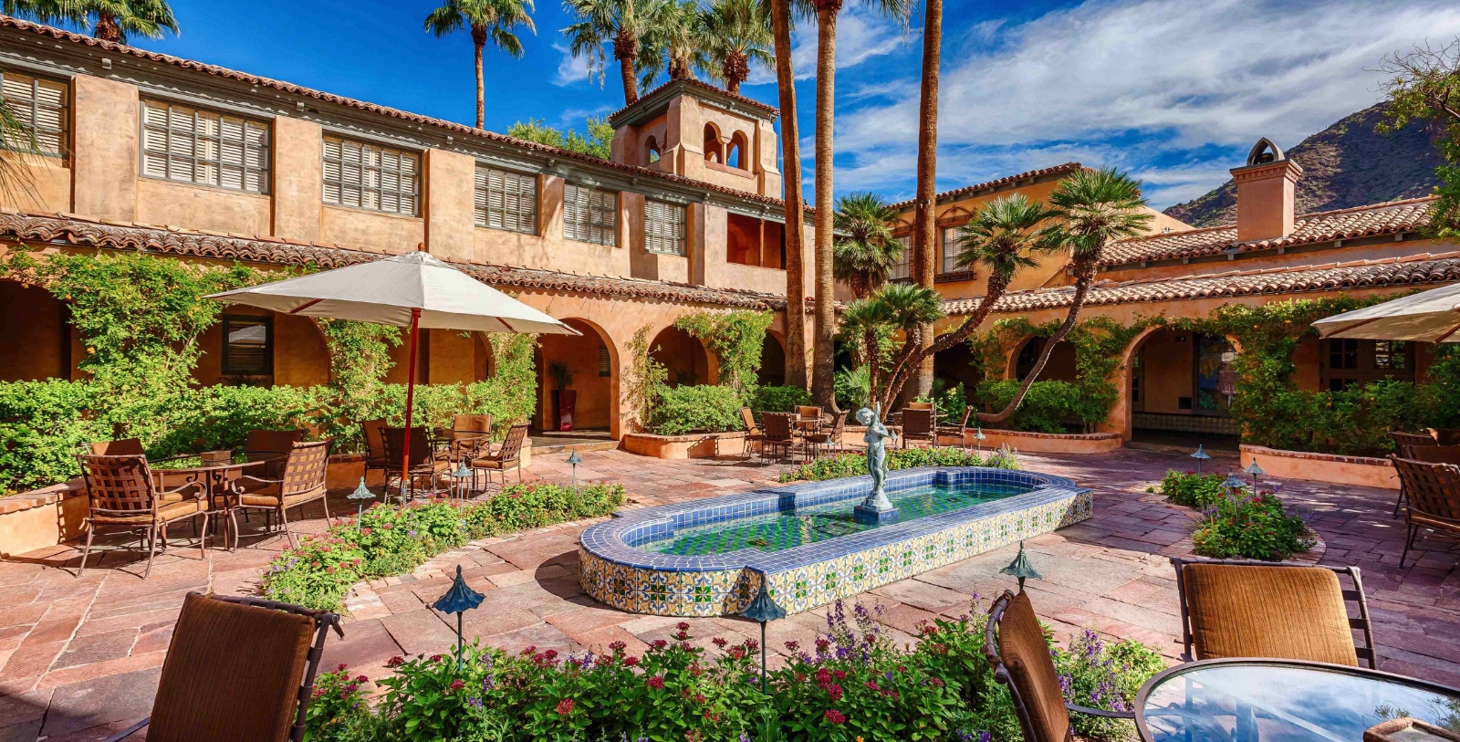 a courtyard with a fountain and palm trees