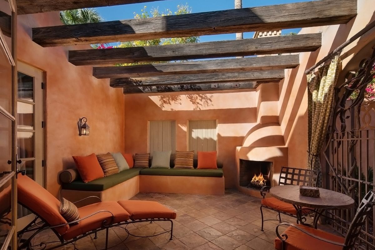 a patio with a wood structure and a bench