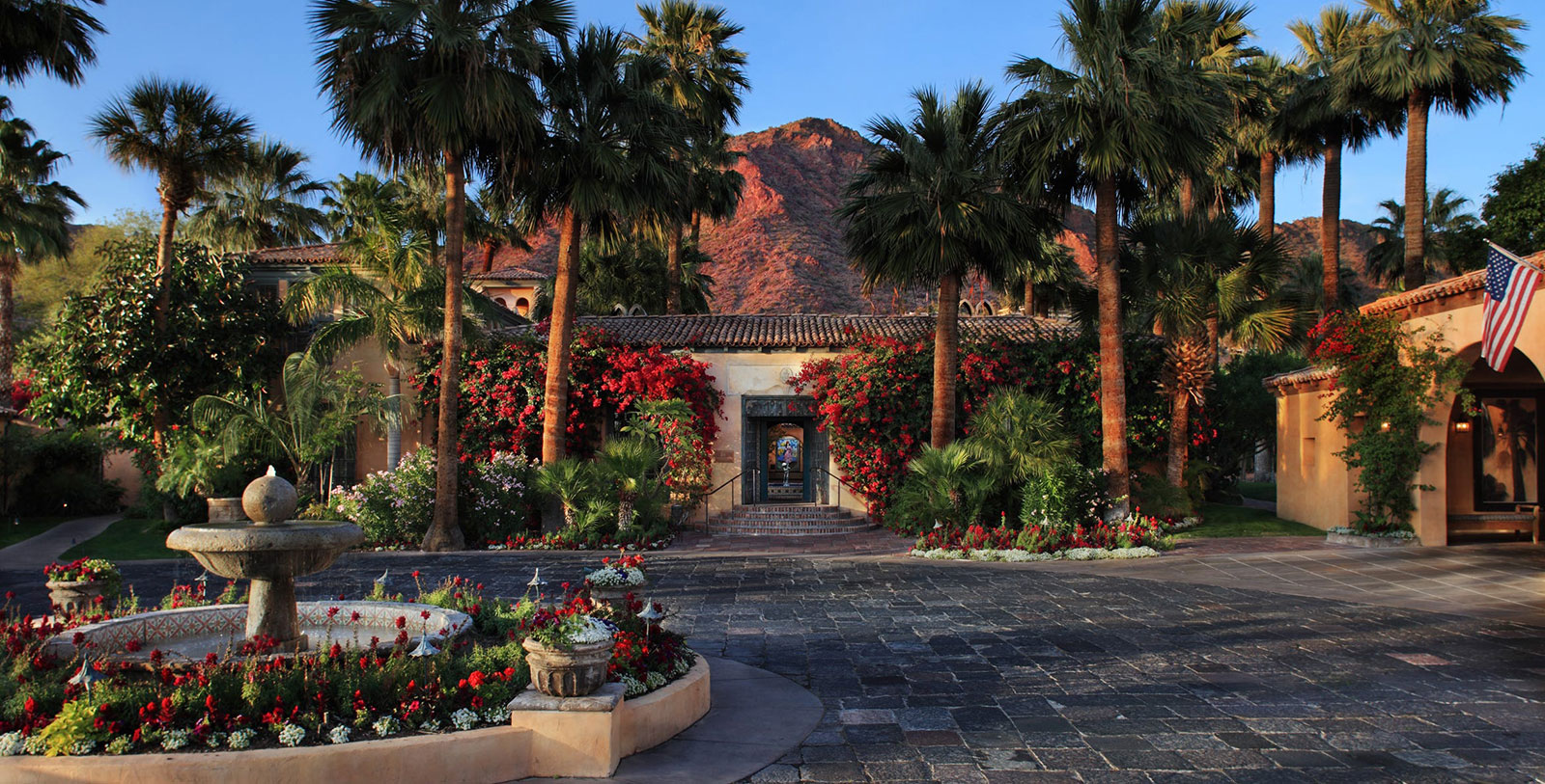 a building with palm trees and flowers