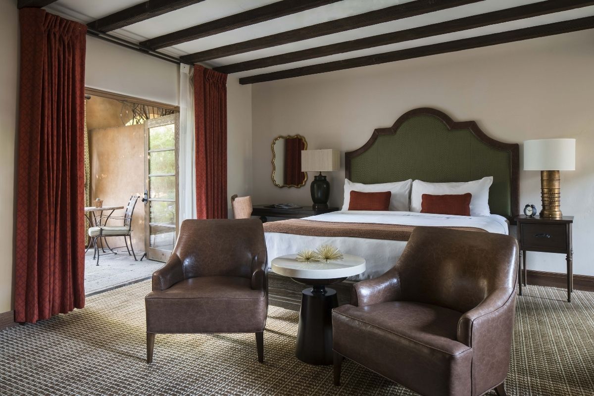 a room with a bed and chairs